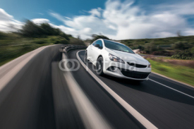 Obrazy i plakaty White car cornering in mountain road with speed blur