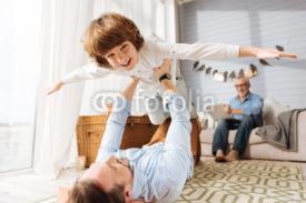 Happy cute boy being held by his father