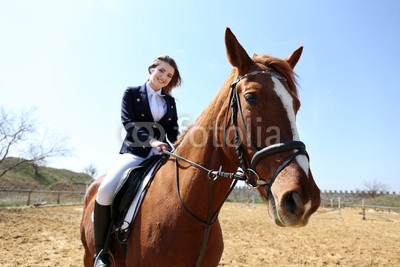 Beautiful girl riding a horse outdoors