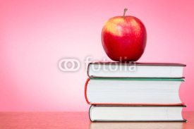 Books and apple with pink background