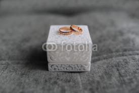 Wedding ring in white cube on grey background