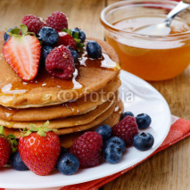 Pancakes with berries and honey closeup
