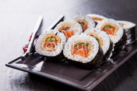 Naklejki Delicious sushi pieces served on black stone