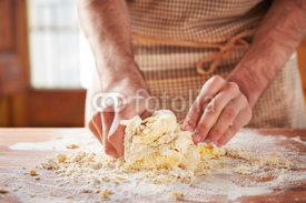 Hands baking dough on wooden table
