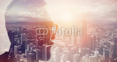 Closeup photo of stylish bearded banker wearing glasses and looking city. Double exposure, panoramic view contemporary megalopolis background. Space for your business message. Wide, sunset effect