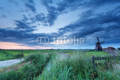 windmill on meadow at sunrise