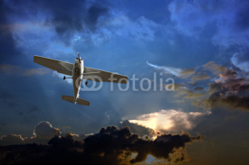 Naklejki Small fixed wing plane against a stormy sky