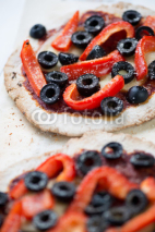 Vertical shot of mini pizzas with red bell pepper and olives