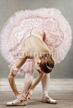 Fototapety Young dancer in beautiful tutu fixing her slippers
