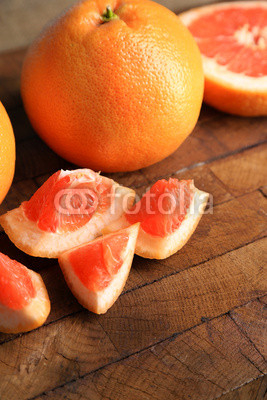 Ripe grapefruits on cutting board, on wooden background