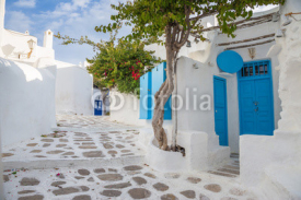 Mykonos traditional white streetview with blue door and trees, Greece