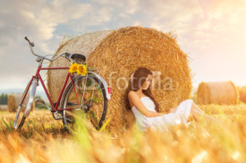 Fototapety Fashion photo, beautiful woman cycling in a wheat field 