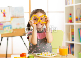 Child girl having fun with food vegetables at nursery room