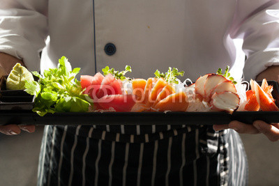 sashimi, a chef uniform holding a dish of Japanese Sashimi