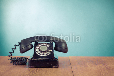 Retro telephone on table in front mint green background