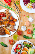 Obrazy i plakaty High Angle View of Grilled Meal of Steak, Chicken and Vegetables Spread Out on Rustic Wooden Table