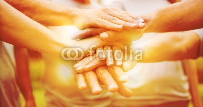 Happy volunteer family putting their hands together 