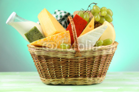 Obrazy i plakaty Basket with tasty dairy products on blue background