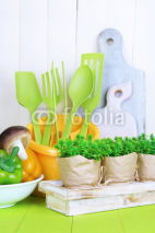 Naklejki Plastic kitchen utensils in cup on wooden table