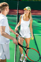 Naklejki Young couple playing tennis