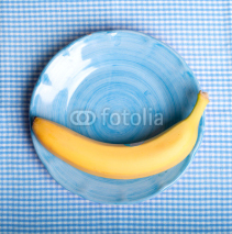 Obrazy i plakaty gelbe Banane auf blauen Teller