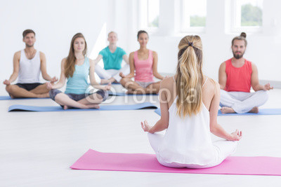 Trainer giving the instructions to the yoga practitioners