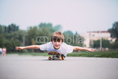 Funny boy lying on a skateboard.