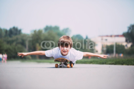Fototapety Funny boy lying on a skateboard.