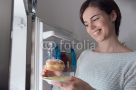 Woman taking a pastry out of the fridge