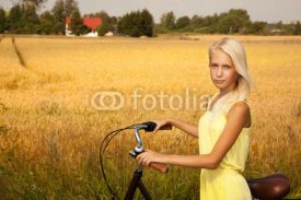 Naklejki Young girl with a bike in the countryside.
