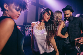 Woman dancing at party with friends at nightclub