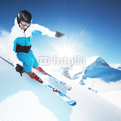 Skier in mountains, prepared piste and sunny day