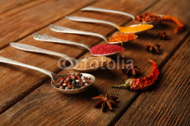 Fototapety Spices in spoons on a wooden background