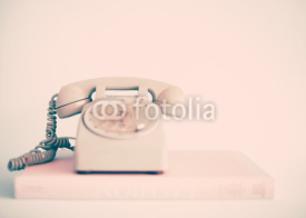 Vintage pink telephone over books