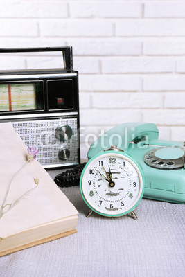 Retro composition with old phone, radio, clock and books, close