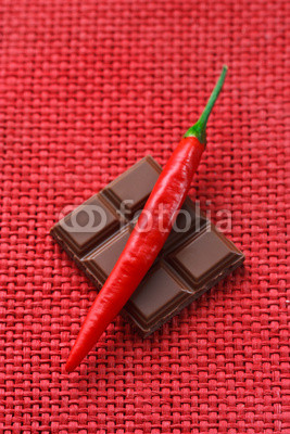 Delicious chocolate and red hot chili on a wicker background.
