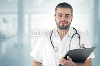Doctor Standing At The Hospital holding a Clipboard