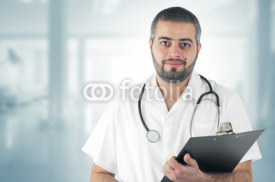 Naklejki Doctor Standing At The Hospital holding a Clipboard