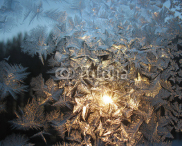 Frosty pattern on winter window and sun
