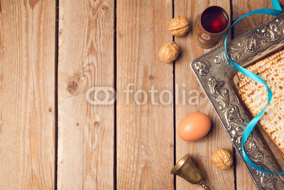 Jewish holiday Passover concept with matzah, seder plate and wine on wooden background. View from above