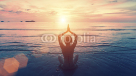 Fototapety Silhouette young woman practicing yoga on the sunset beach. Tranquility and concentration.