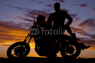 woman lay back on motorcycle man stand silhouette