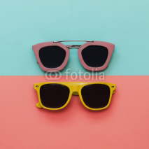 Flat lay fashion set: two sunglasses on pastel backgrounds. Top view.
