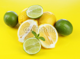 Naklejki Lemons and limes, on yellow background