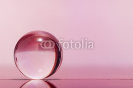 Naklejki Glass transparent ball on light pink background and mirror