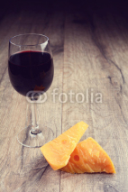 Naklejki Cheese on the table with glass of wine