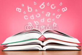 Open books with glowing letters flying out