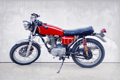 vintage color style of old classic motorcycle standing against w