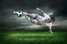 Naklejki Football player with ball in action under rain outdoors