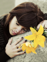 Naklejki Sad young woman lying on the tombstone